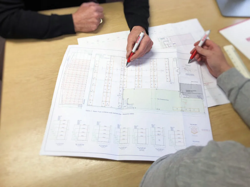 two people working on printed autocad drawing