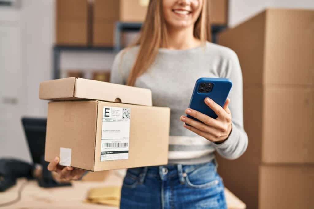 person carrying parcels and looking at mobile phone