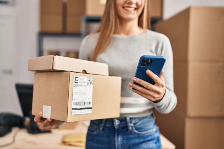 person carrying parcels and looking at mobile phone